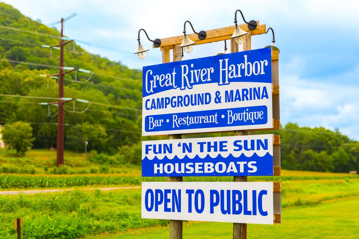 Great River Harbor campground and marina sign listing bar, restaurant, boutique, houseboats, and open to the public.