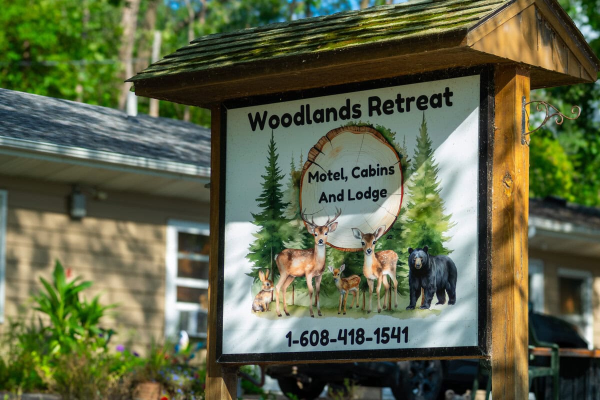 Woodlands Retreat sign with deer and bear, Wisconsin outdoor lodge, family-friendly recreational area, explore Buffalo County.